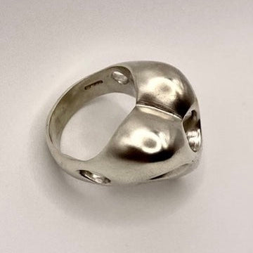 Sterling silver heart-shaped ring on a light gray background