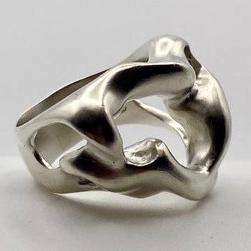 Silver ring with a knot design on a light gray background