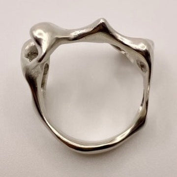 Silver ring with a unique design on a light gray background