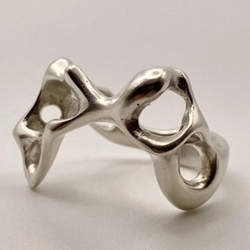 Silver ring with a unique design on a light gray background