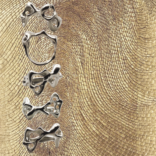 Set of silver rings on a textured gold background