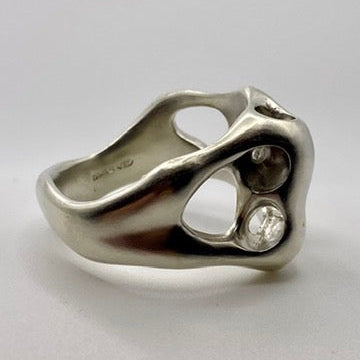 Silver organic ring on a light gray background