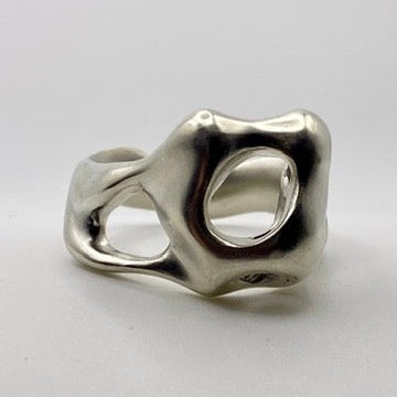 Silver abstract ring on a light gray background