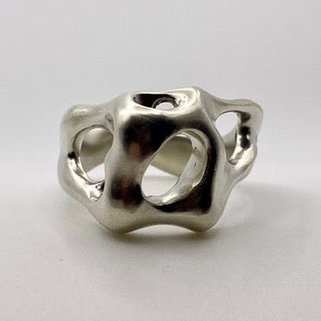 Silver ring with a unique design on a light gray background