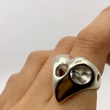 Sterling silver heart-shaped ring on a light gray background