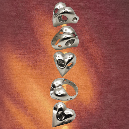 Set of metallic heart-shaped objects rings on a gradient background